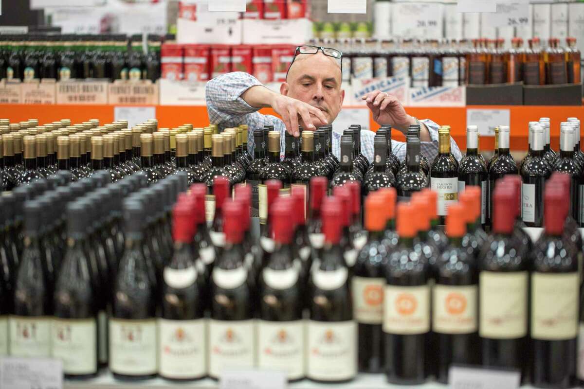 Paul Ferris, a wine steward at Costco, stocks wine at the store on 10th Street in San Francisco.