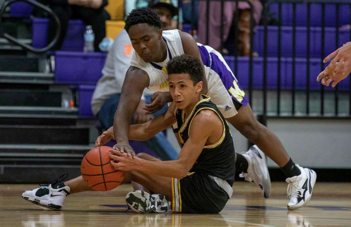 Midland High’s Davion Mosely attempts to get the ball from Snyder’s Jared Smith on Tuesday, Dec. 7, 2021 at Midland High School. Jacy Lewis/Reporter-Telegram