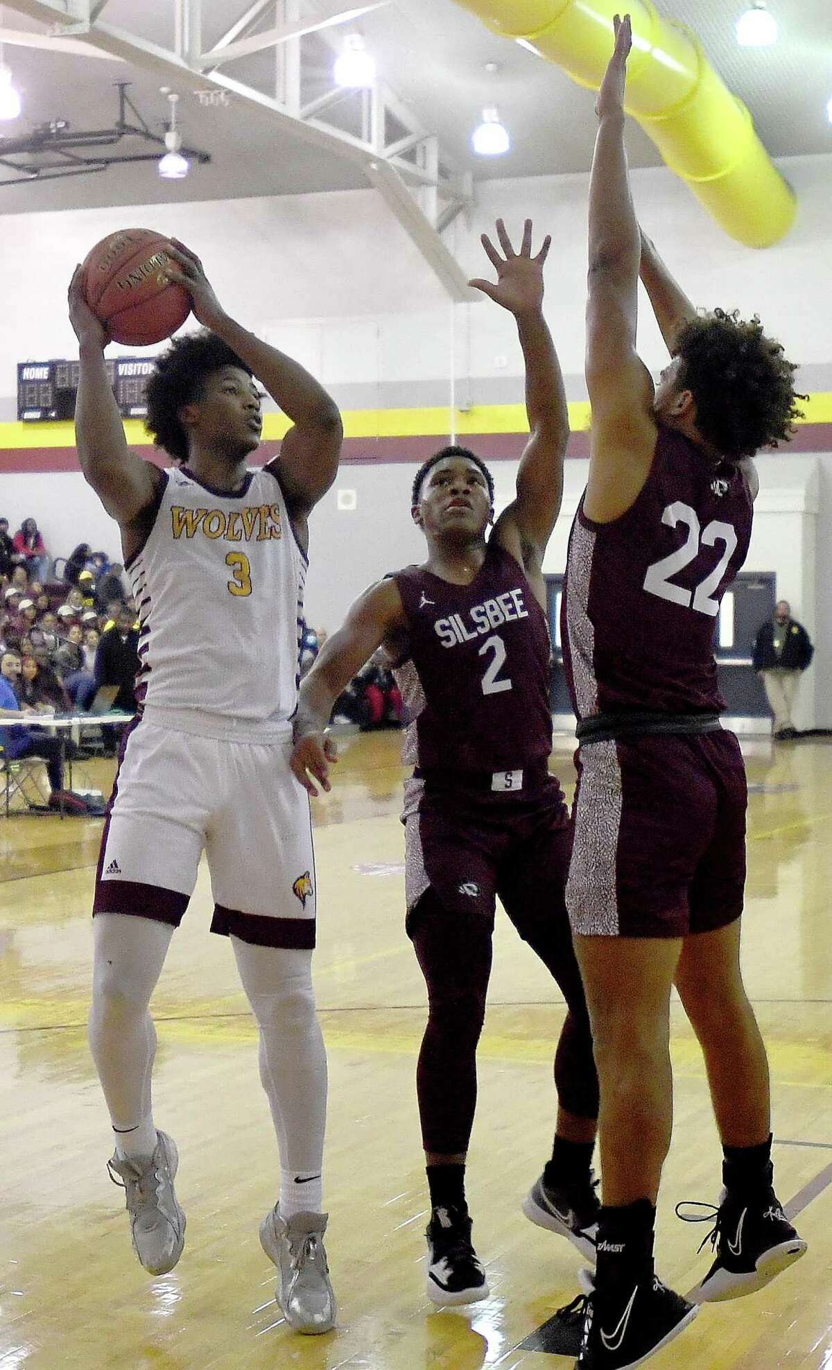Beaumont United's Wesley Yates looks for a shot against Silsbee's Dre'Lon Miller and Mason Brisbane during Tuesday's game at BU. Photo made Tuesday, December 7, 2021 Kim Brent/The Enterprise