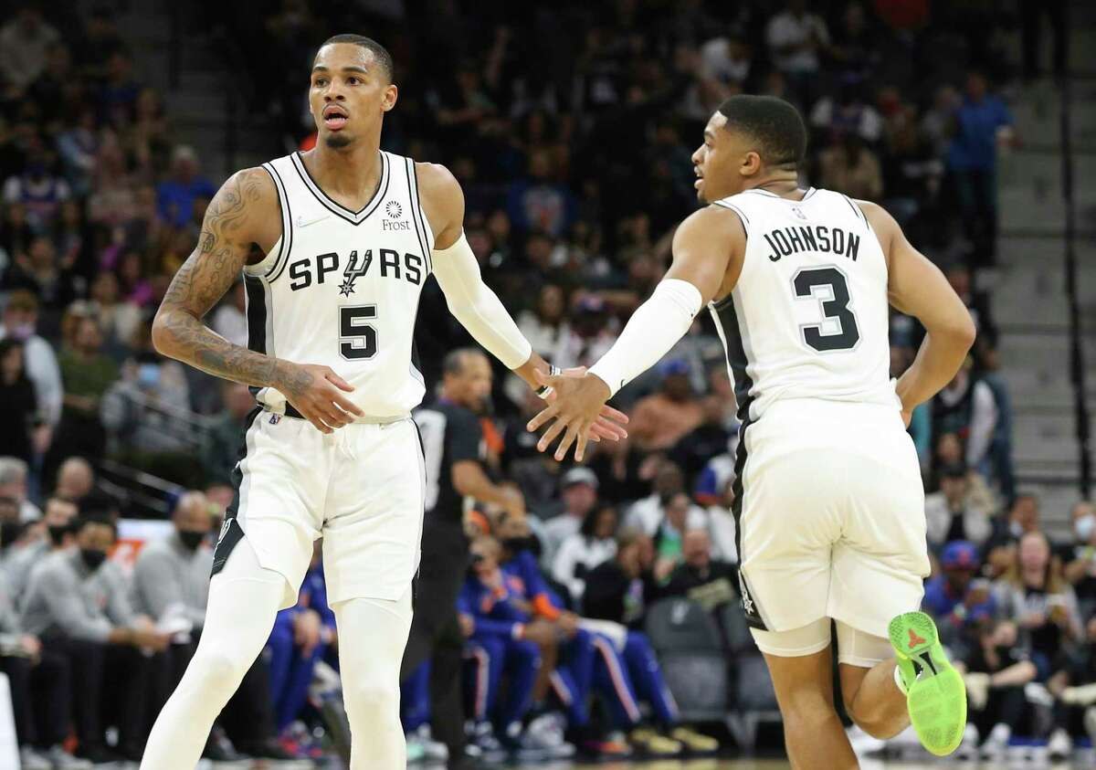 Spurs’ Dejounte Murray (5) and Keldon Johnson (3) slap hands after a score against the New York Knicks at the AT&T Center on Tuesday, Dec. 7, 2021.