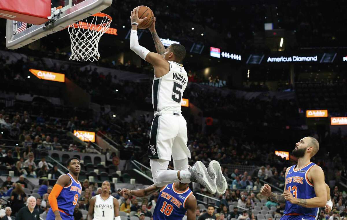 Spurs’ Dejounte Murray (5) scores on a dunk against the New York Knicks at the AT&T Center on Tuesday, Dec. 7, 2021.
