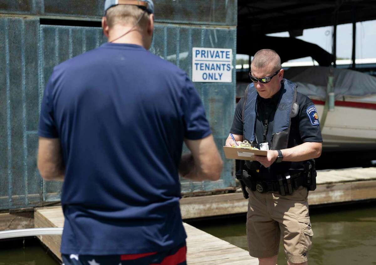 In this Sept. 4, 2021 file photo, Montgomery County Constable Precinct 1 Deputy Jarrett Rhodes conducts a safety check for a boater during Labor Day Weekend at Stowaway Marina & RV Park in Lake Conroe. The year saw an increase in fatalities on the popular lake compared to previous years.