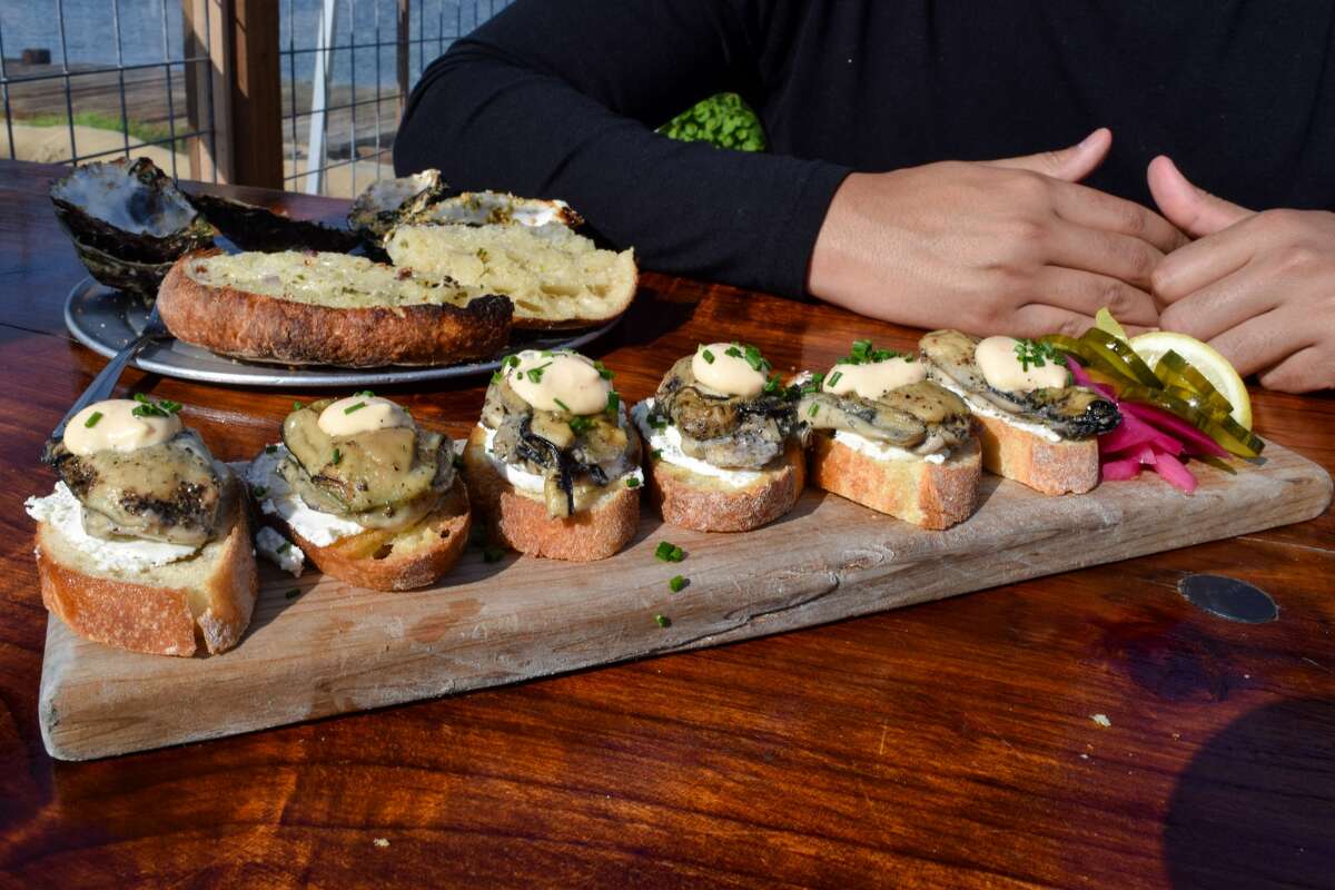 An order of smoked oysters, served on crostini with Fromage Blanc cheese, chipotle aioli, chives, and a wedge of lemon at the Marshall Store on Tomales Bay in Marshall, California.