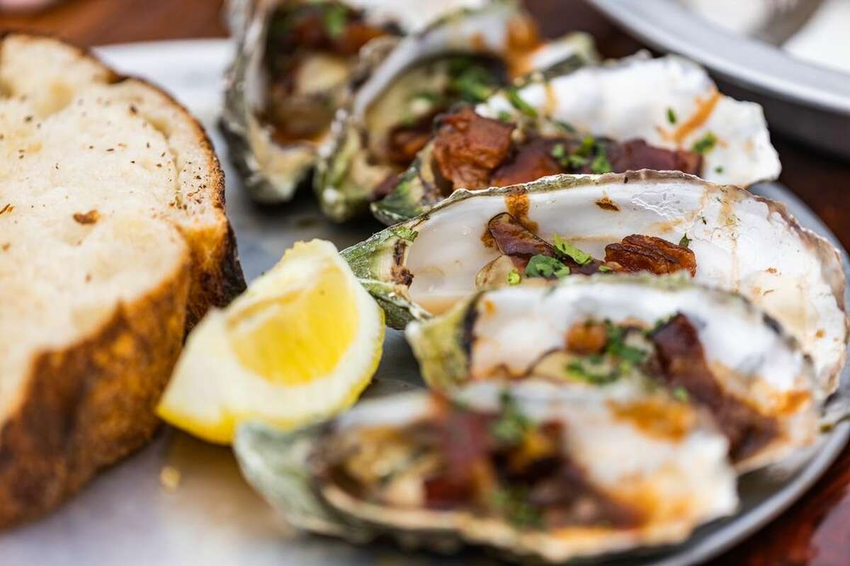 An order of the Kirkpatrick, with grilled oysters cooked with garlic butter, Worcestershire sauce, bacon, and topped with fresh parsley at the Marshall Store on Tomales Bay in Marshall, California.