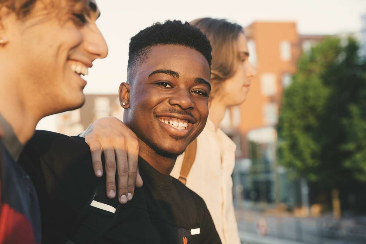 Portrait of a young man smiling with friends.