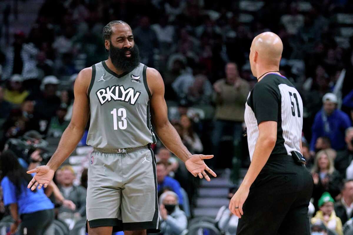 Brooklyn Nets guard James Harden talks to referee Aaron Smith during the first half of the team's NBA basketball game against the Dallas Mavericks in Dallas, Tuesday, Dec. 7, 2021. (AP Photo/Tony Gutierrez)