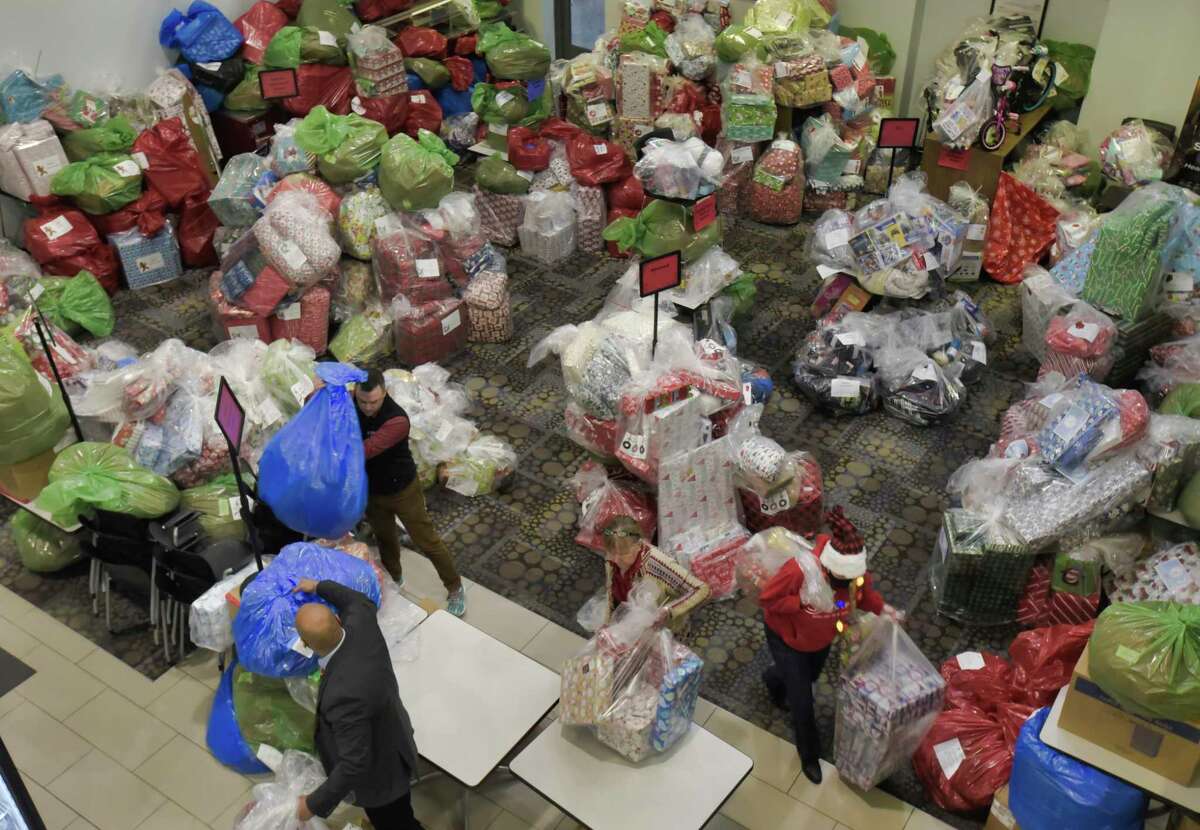 Los empleados de SEFCU comienzan a llevar regalos envueltos a un vehículo para entregarlos a varias organizaciones en el área de la capital el miércoles 8 de diciembre de 2021 en Albany, NY.  Por trigésimo año, SEFCU sirve a la comunidad a través del programa anual de vacaciones compartidas de la compañía.  Durante esta temporada navideña, SEFCU donará más de $200,000 en obsequios a personas en comunidades de todo el estado donde la cooperativa de ahorro y crédito tiene oficinas, incluida la Región Capital, Buffalo, Binghamton y Syracuse.  Así lo dijo Tom Schreck, director de comunicaciones de Wildwood, una de las organizaciones que recibió donaciones. "SEFCU y su personal han sido muy generosos con nuestra organización y han apoyado nuestros programas a lo largo de los años.  Esta donación proporcionará obsequios para unas 75 personas y servimos a todos los grupos de edad.  Imagina que eres un hombre de 45 años sin familia y que vive solo, sin este programa a través de SEFCU no recibiría ningún regalo en esta festividad."