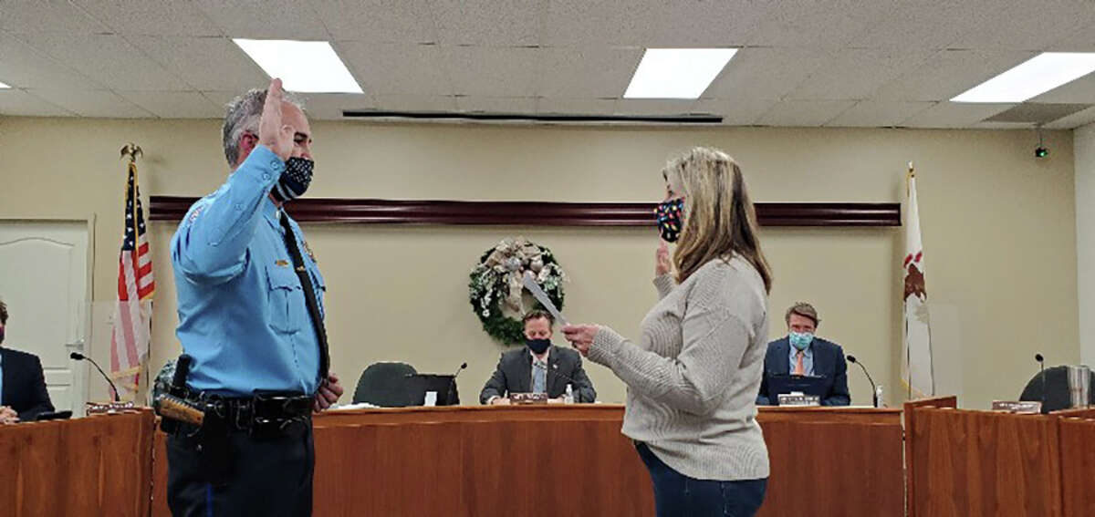 Barry Jones, left, repeats an oath of office from City Clerk Michelle Boyer to become a police lieutenant Tuesday during a city council meeting. Jones is a 15-year veteran of the department.