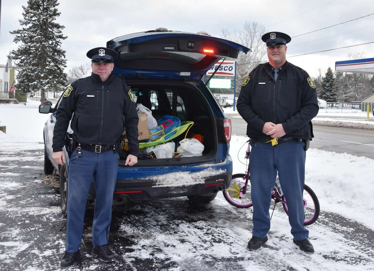 (From left) Michigan State Police Troopers Christopher Ingalls and David Skorka were at the ready to receive donated toys for the Stuff the Blue Goose campaign in Manistee on Wednesday.