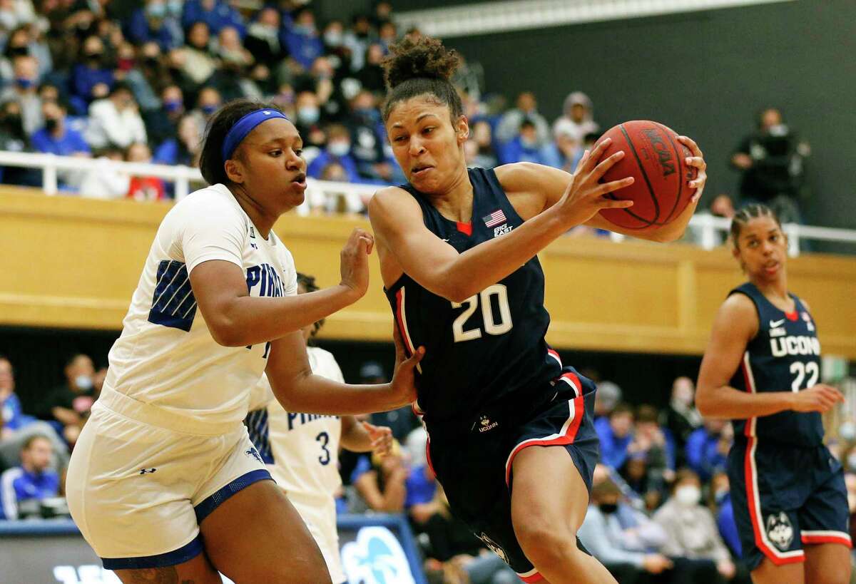 Connecticut forward Olivia Nelson-Ododa (20) drives to the basket against Seton Hall forward Sidney Cooks during the second half of an NCAA college basketball game on Friday, Dec. 3, 2021, in South Orange, N.J. (AP Photo/Noah K. Murray)