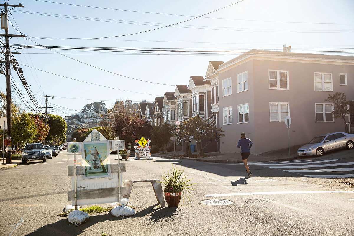 A runner jogs along Sanchez Street, part of San Francisco's Slow Streets Program in the Noe Valley neighborhood of San Francisco, Calif. Saturday, Nov. 13, 2021.