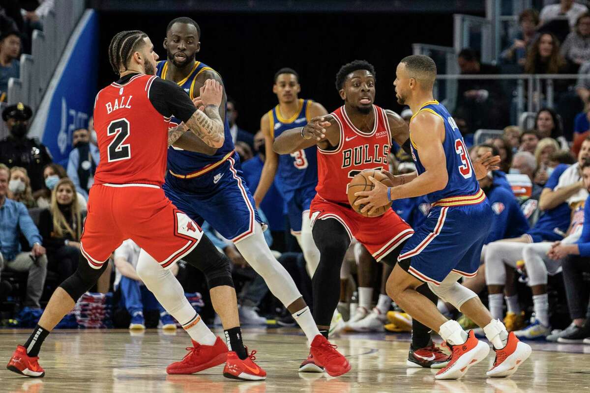 Golden State Warriors guard Stephen Curry drives the ball as teammate forward Draymond Green prepares to set a screen during the fourth quarter of their NBA basketball game against the Chicago Bulls in San Francisco, Calif. Friday, Nov. 12, 2021.