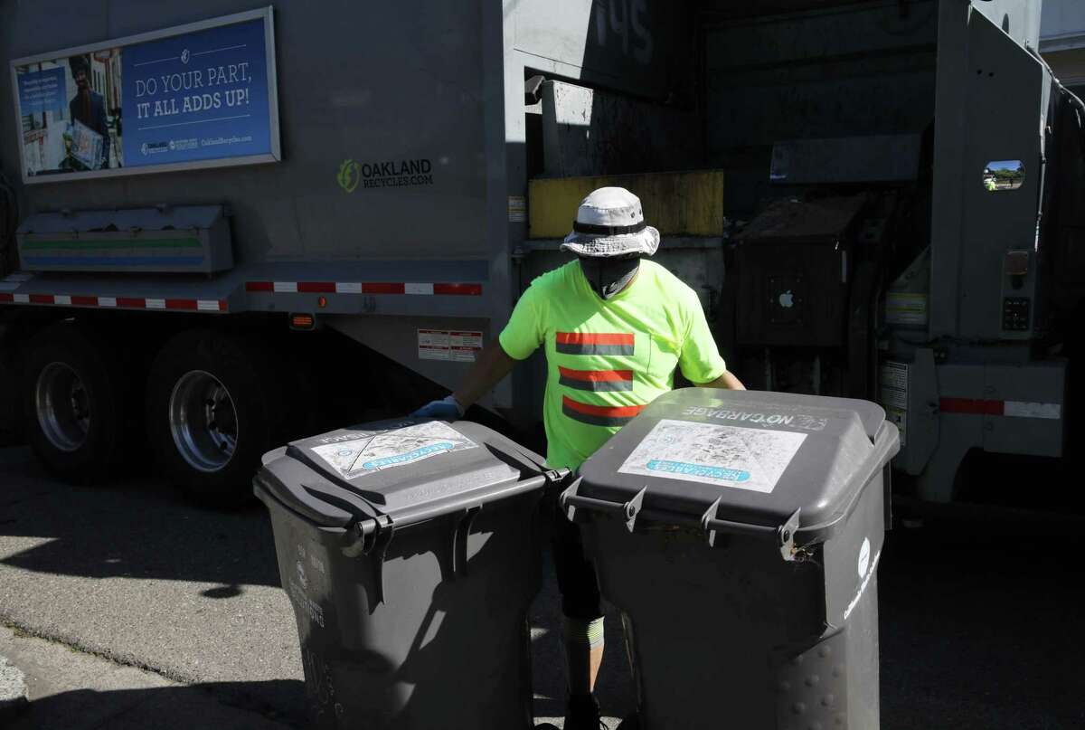 Alvin Aragon of California Waste Solutions works in Oakland’s Rockridge district on April 22, 2020. The company handles pickup of recyclables in the city.