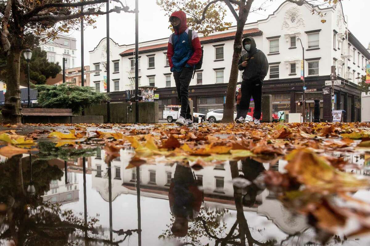People carry umbrellas while walking onto the UC Berkeley campus along Bancroft Way in Berkeley, Calif. A weak atmospheric river is headed to the S.F. Bay Area, bring rain to the region and piles of snow to the Sierras.