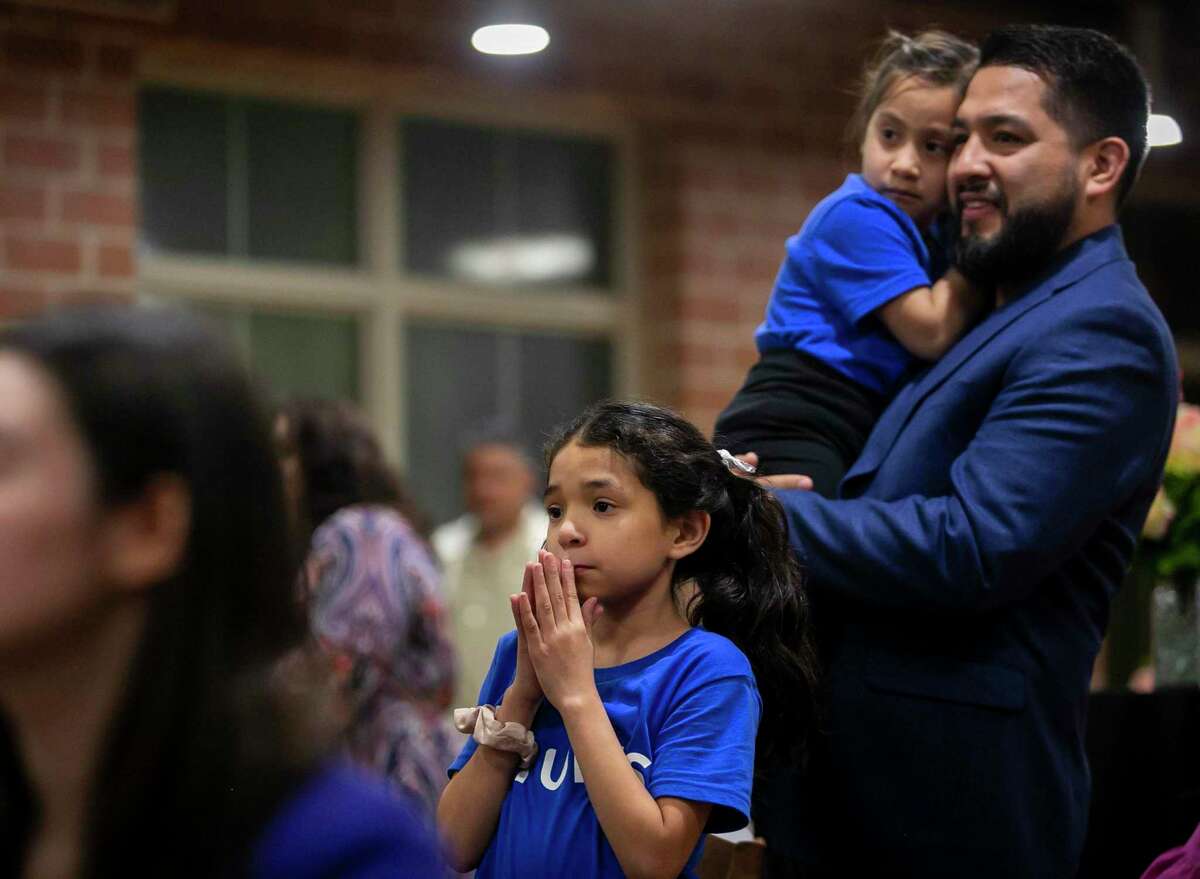 Victoria Ginez, 9, anxiously watches her mother Mayra Ginez present her business, Turis Bikes, as her father, Juan Ginez, holds her sister Caroline Ginez, 5, during the Embracing Entrepreneurial Equity program graduation at the Maestro Entrepreneur Center in San Antonio on Wednesday.