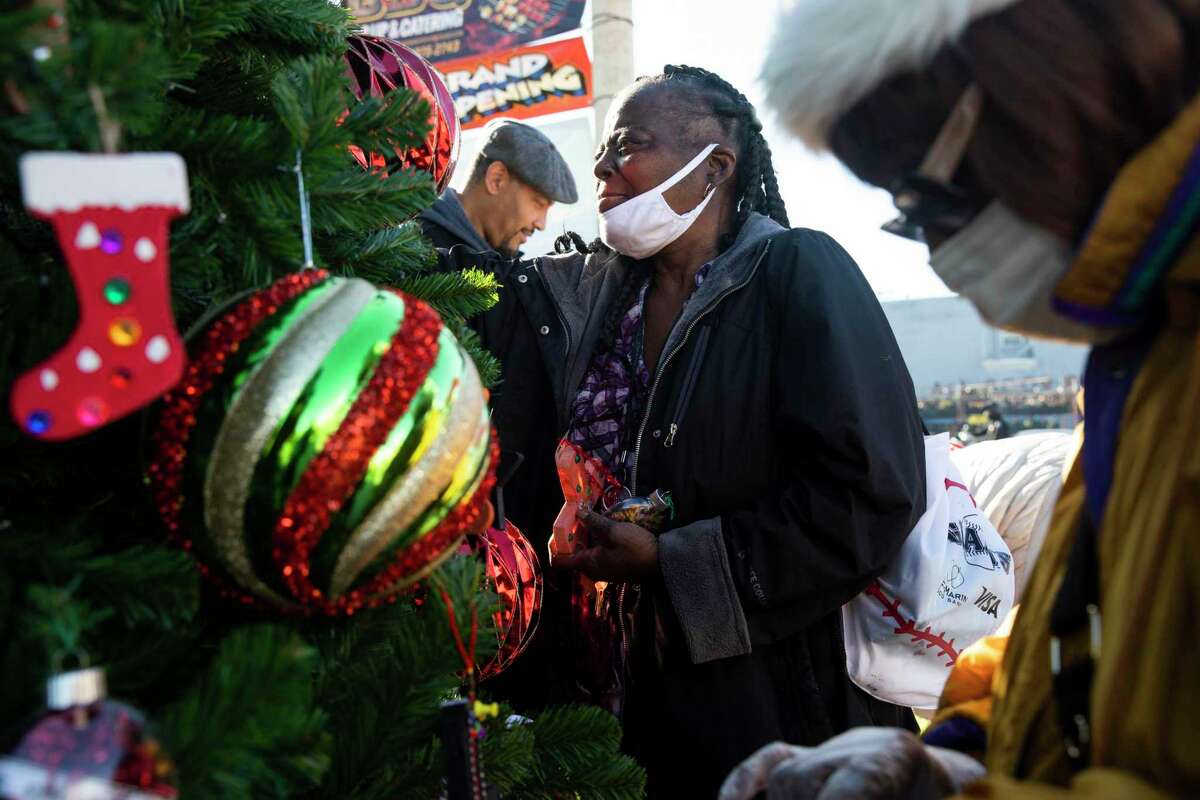 Juanita Jackson (center) and Mary Fleming work alongside volunteers to decorate a tree donated by Wells Fargo in the Bayview district last week.