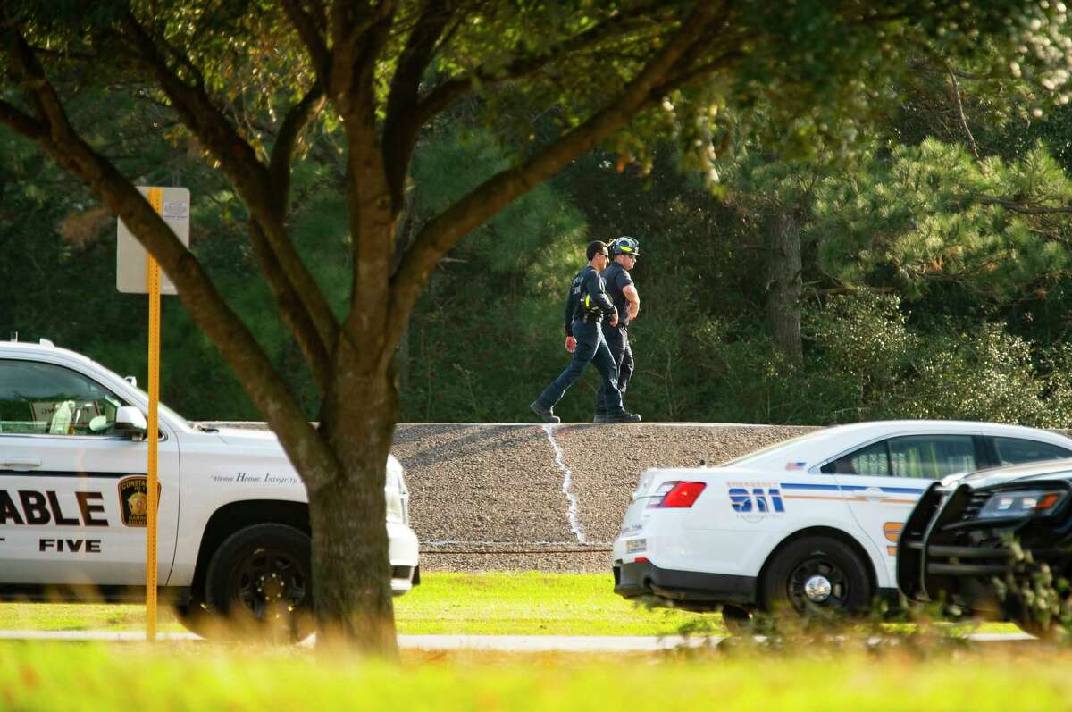 Firefighters walked down Barker Dam near the site where fire and police are responding to a reported small plane crash in the reservoir that killed two people, according to law enforcement, Thursday, Dec. 9, 2021, in Houston.