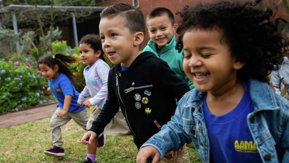 AAMA's Early Childhood Center PreK-3 students Aldo Cornejo, center, and Jeremiah Green, 3, play “red light, green light' in a courtyard, Wednesday, Dec. 8, 2021, in Houston.