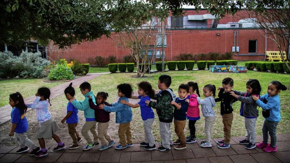 AAMA's Early Childhood Center PreK-3 students get in line to enter indoors for reading time after playing 