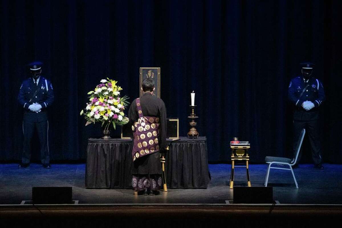 Reverend Yushi Mukojima chants before the altar during a memorial service for Kevin Nishita at the San Jose Civic Auditorium on Thursday, Dec. 9, 2021.