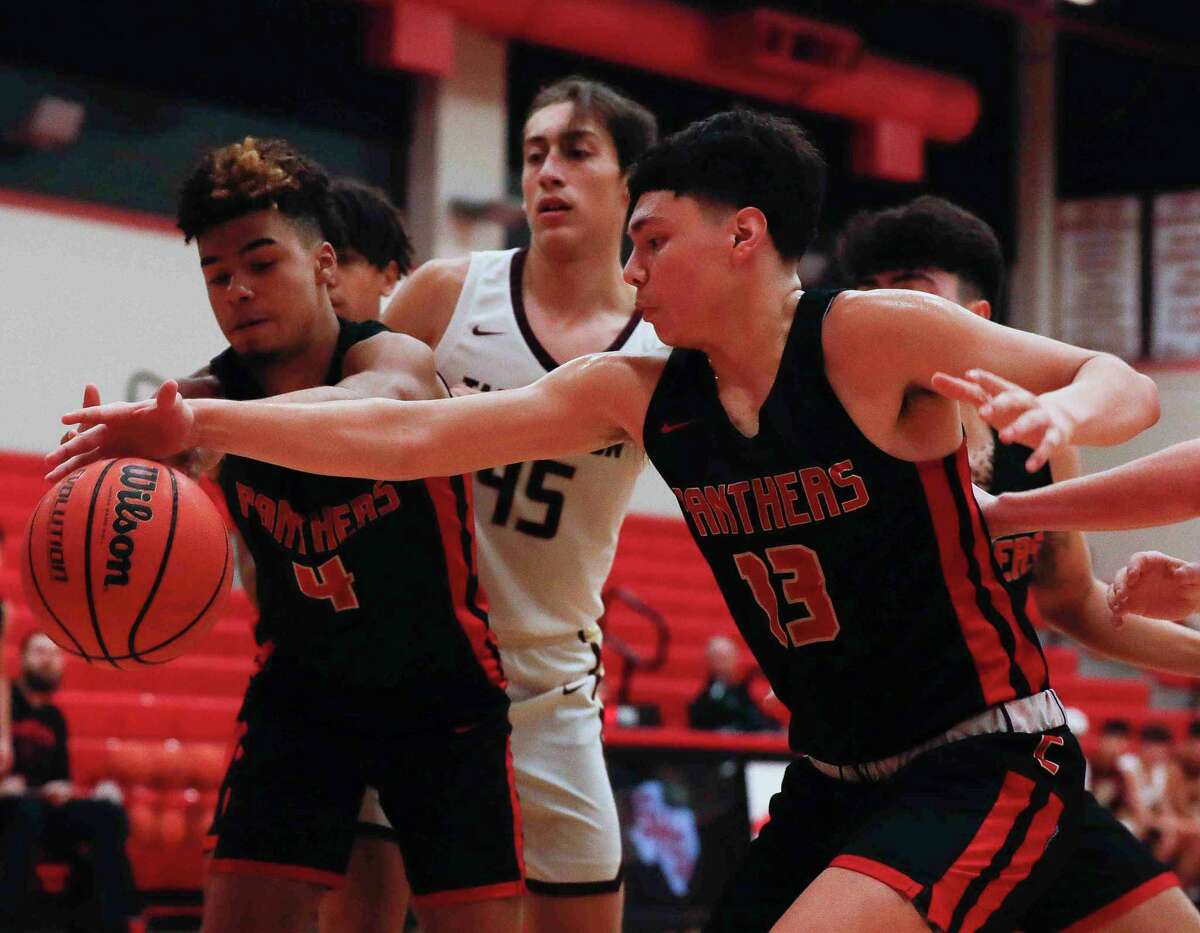 Caney Creek guards Tony Gonzales (13) and Travis Pinder (4) go after a loose ball during a high school basketball game at Splendora High School, Thursday, Dec. 9, 2021, in Splendora.