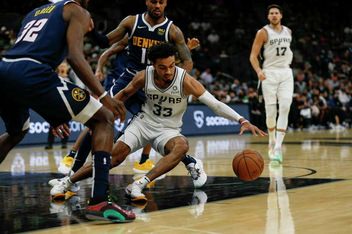 San Antonio Spurs guard Tre Jones (33) recovers a loose ball during the second quarter against the Denver Nuggets at AT&T Center in San Antonio, Texas, Thursday, Dec. 9, 2021.