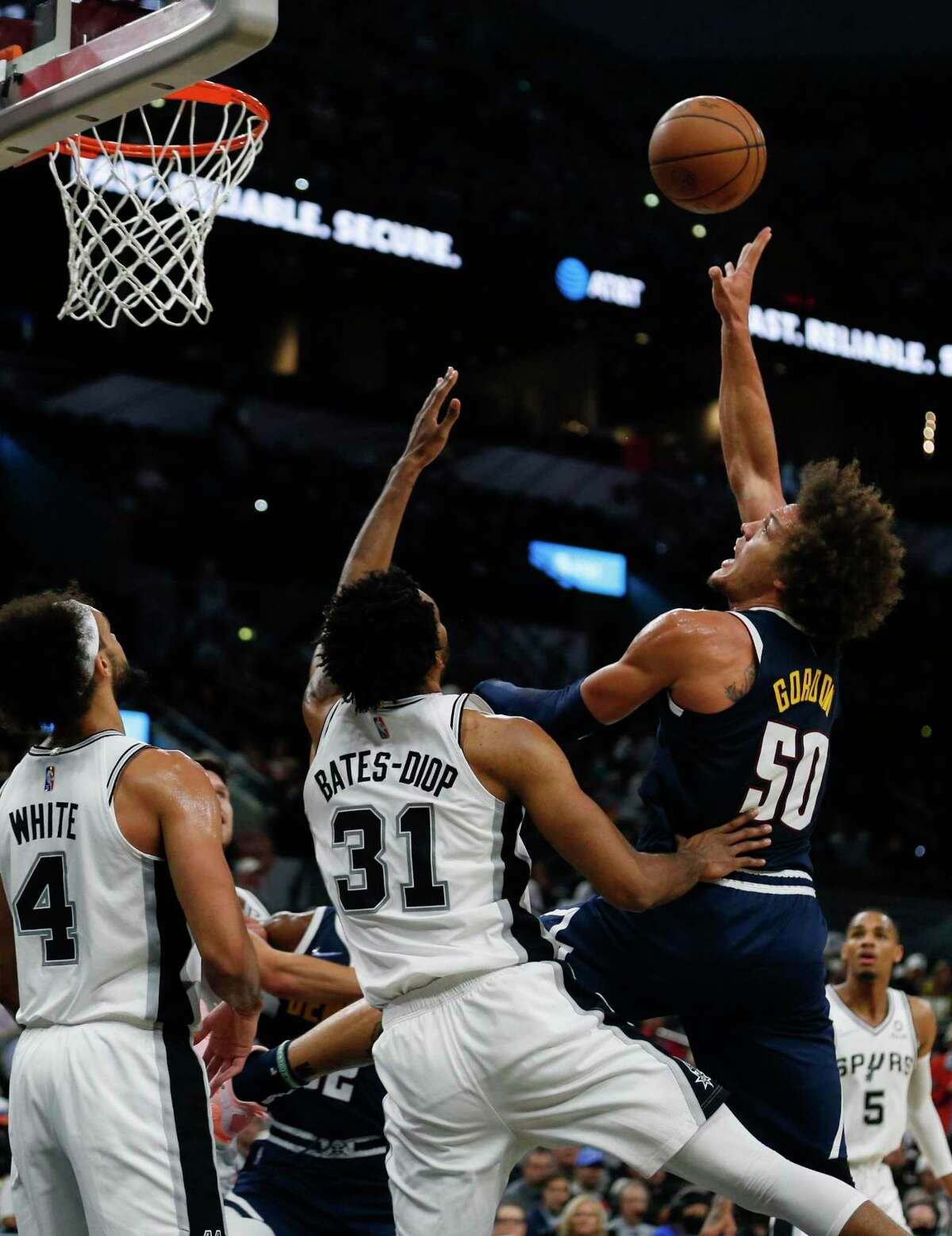 Denver Nuggets forward Aaron Gordon (50) shoots over San Antonio Spurs forward Keita Bates-Diop (31) and guard Derrick White (4) at AT&T Center in San Antonio, Texas, Thursday, Dec. 9, 2021. The Spurs defeated the Nuggets, 123-111.