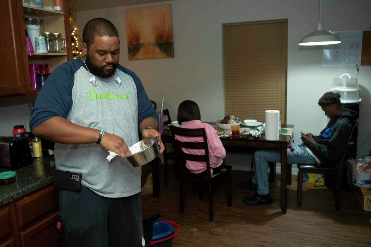 LaRon Doss cleans out a dog bowl Thursday, Dec. 2, 2021 in Houston. The National Flood Insurance Program has required multiple bailouts from Congress, as its rates fall short of covering the damages sustained by enrolled homeowners. So it is recalculating its pricing -- and Houston-area insurance brokers say that change will cause some of their clients’ rates to eventually go up hundreds or even thousands of dollars. Doss, who owns a Habitat home in East Houston, says the added cost will cause her family to make sacrifices as one of her children graduates from high school. "The money you used to make cover the expense of living, it's not covering the cost of living anymore," she said.