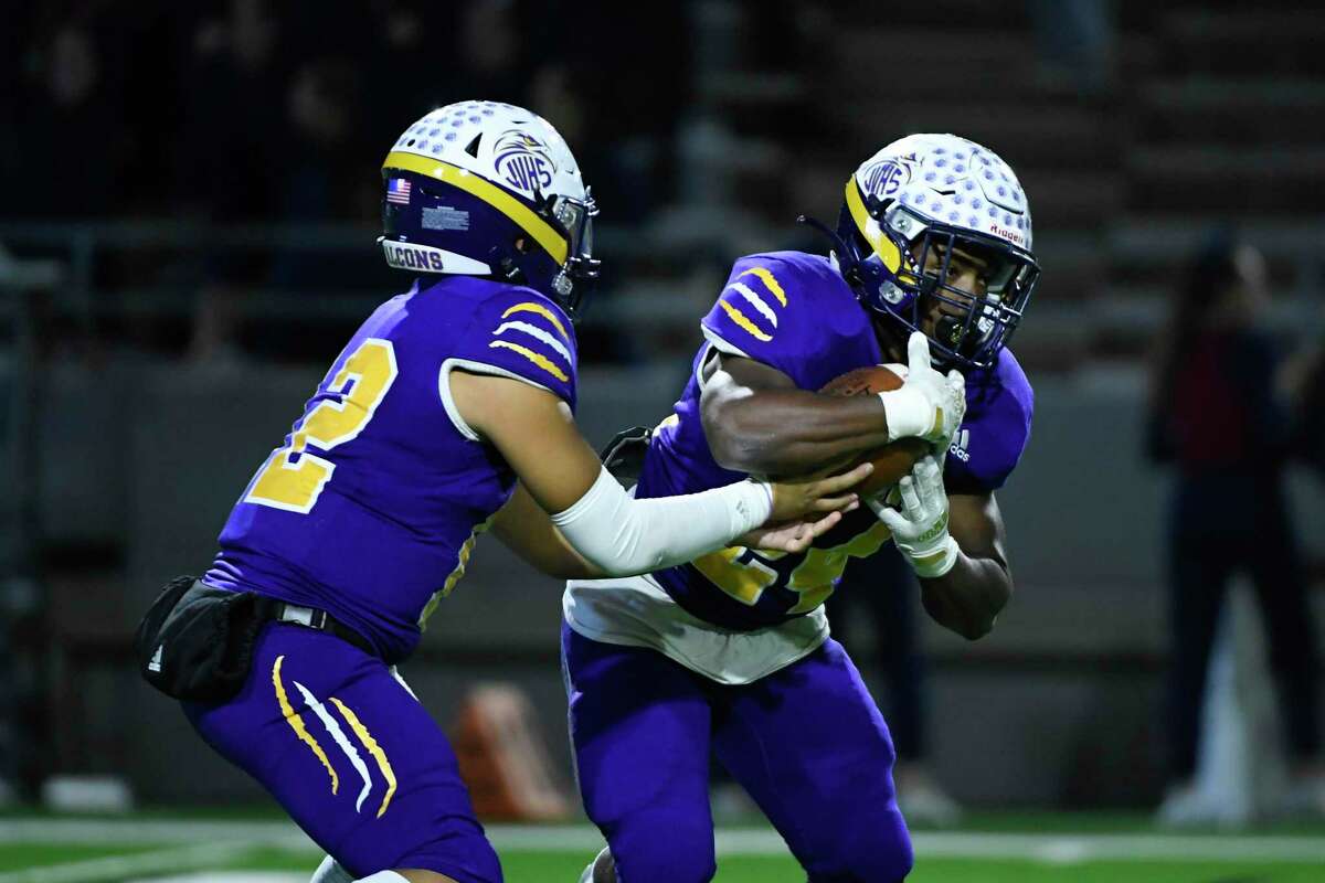 Jersey Village’s Adam Tran (12) hands off to Rashon Estes (24) against Tompkins during the second half of a 6A Division I area playoff game Friday, Nov. 19, 2021, in Houston.