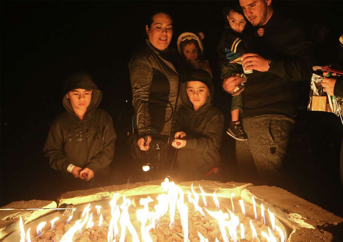 Yandel Ortiz (from left), 7, Erika Ortiz holding Hanna Ortiz, 1, Nathan Ortiz, 5, and James Alamillo, holding Ethan Jase, 2, enjoy roast marshmallows for s'mores and enjoy hot chocolate following the Country Christmas Hayride during Christmas at the Caverns at Natural Bridge Caverns on Friday, Dec. 4, 2015.