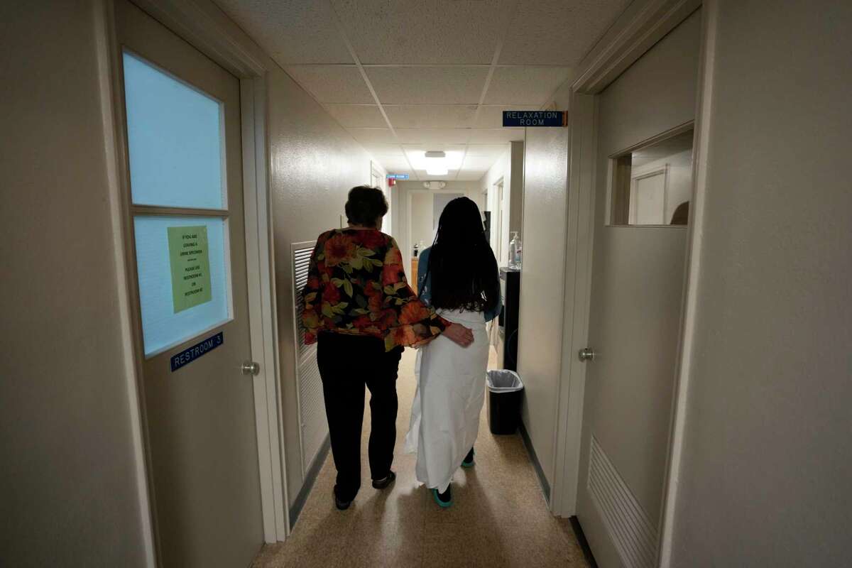 A 33-year-old mother of three from central Texas is escorted down the hall by clinic administrator Kathaleen Pittman prior to getting an abortion, Saturday, Oct. 9, 2021, at Hope Medical Group for Women in Shreveport, La. The woman was one of more than a dozen patients who arrived at the abortion clinic, mostly from Texas, where the nation's most restrictive abortion law remains in effect.