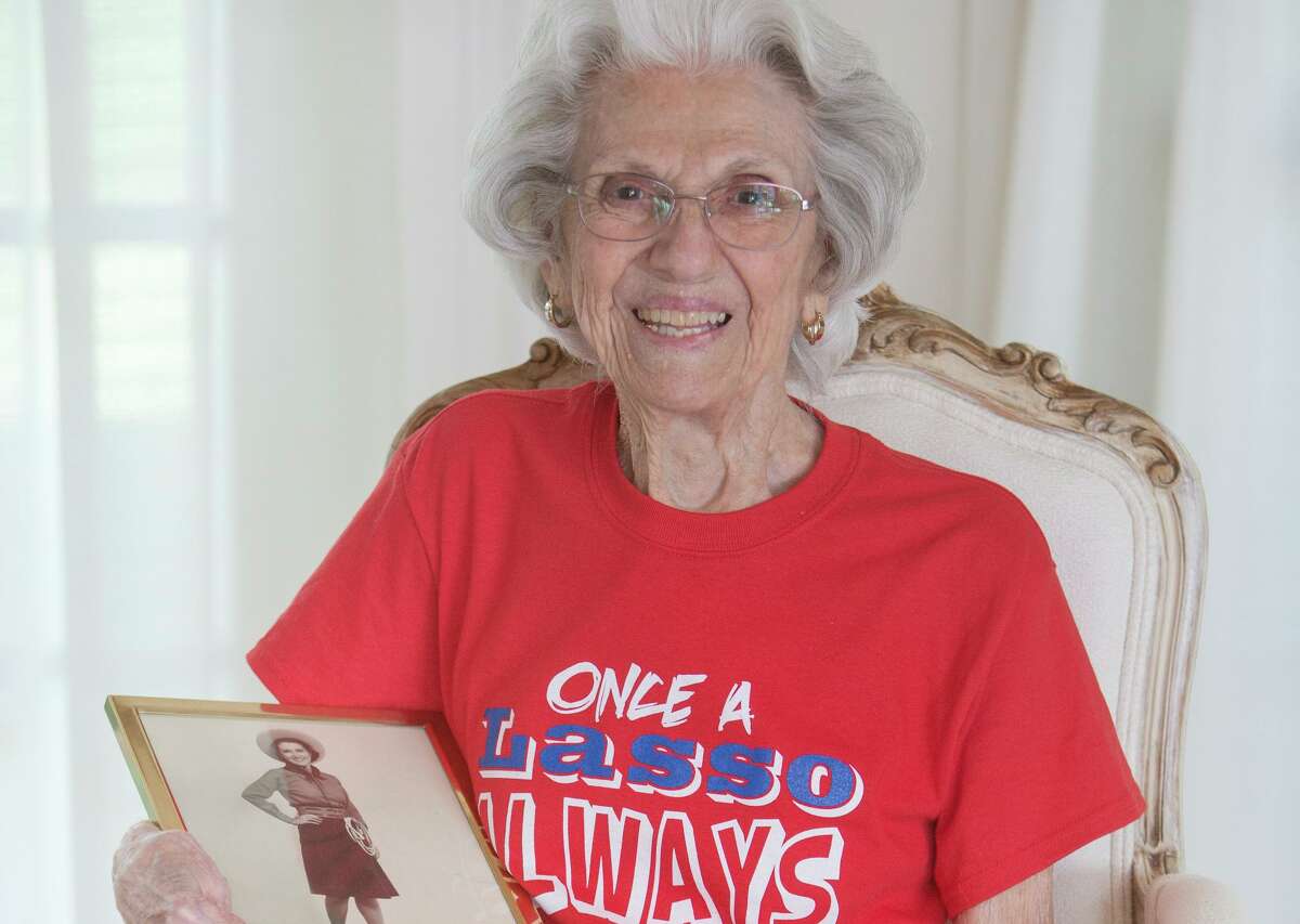 Dorothy Hughes, at age 98 the oldest living Thomas Jefferson High School Lasso, poses in her home with a high school picture of herself in her Lassos uniform. Hughes graduated from Jefferson in 1941.