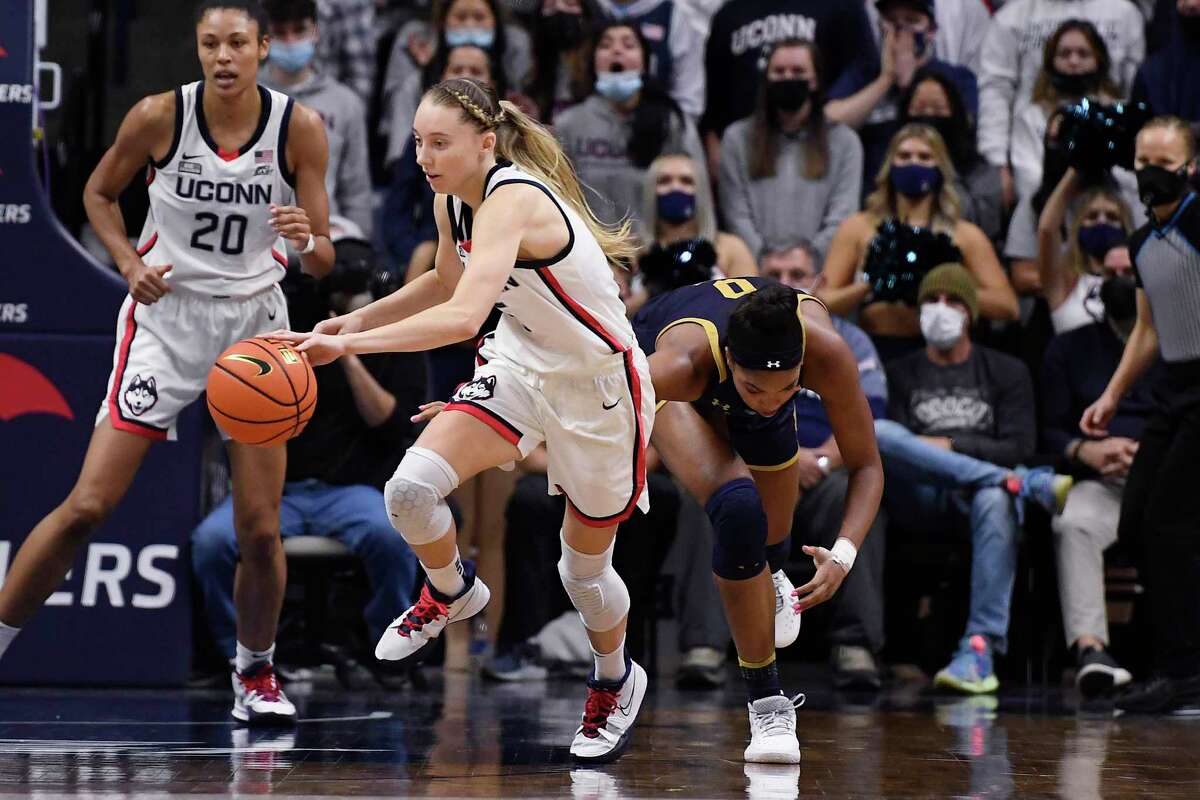 Connecticut's Paige Bueckers, left, steals the ball from Notre Dame's Maya Dodson, right, in the second half of an NCAA college basketball game, Sunday, Dec. 5, 2021, in Storrs, Conn. (AP Photo/Jessica Hill)