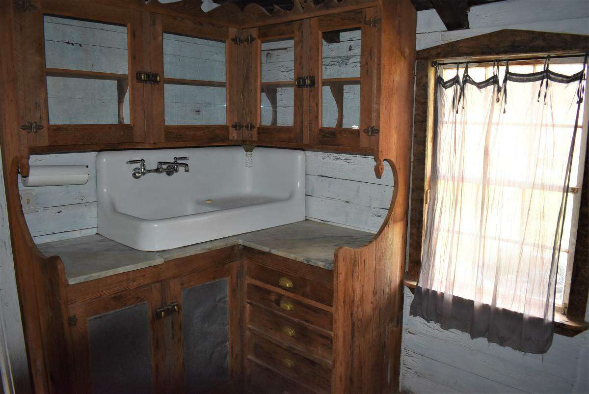 The antique sink is built on top of cabinets.