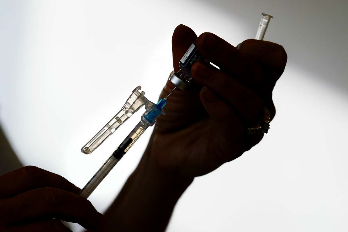 FILE - A syringe is prepared with the Pfizer COVID-19 vaccine at a clinic in the Norristown Public Health Center in Norristown, Pa., on Tuesday, Dec. 7, 2021.
