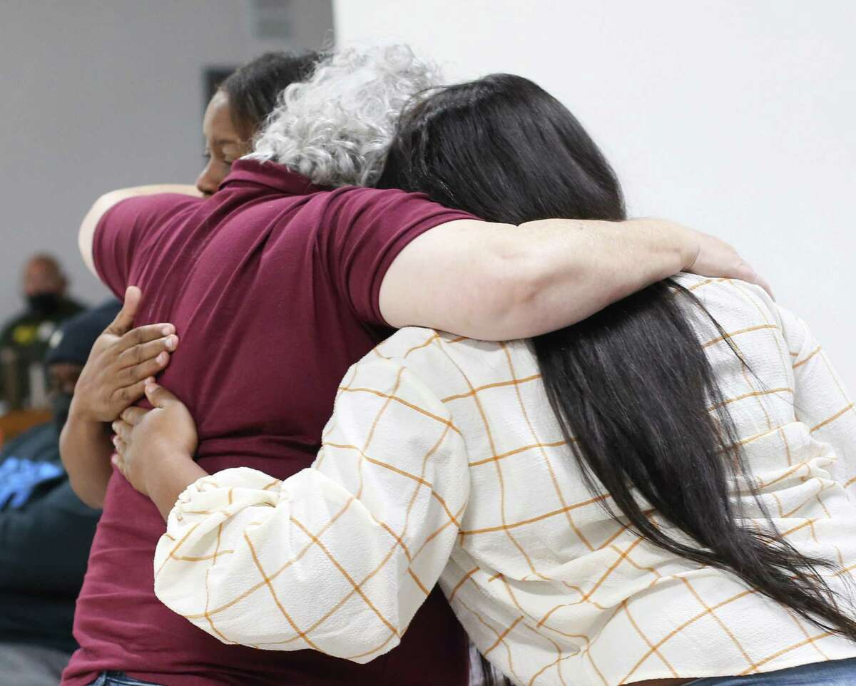 Child Protective Services social workers hug after speaking out about violence against them during a town hall discussion of the CWOP issue with local CPS folks, foster care nonprofit leaders, elected officials and CPS staff present at the AFL-CIO Hall in Houston on Saturday, Dec. 4, 2021.