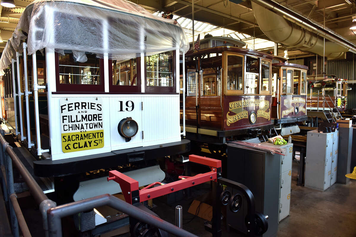 A selection of different cable cars that are installed for repair in the mechanic's pit in the working cable car garage above the museum. 