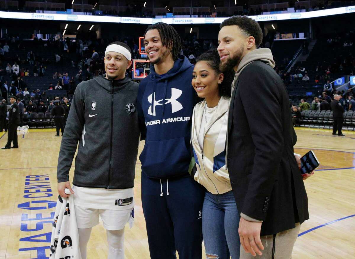 Stephen Curry (30), right, poses for a photo with (l-r) his brother, Seth Curry, brother-in-law Damion Lee, and sister Sydel Curry-Lee, after the Golden State Warriors played the Dallas Mavericks at Chase Center in San Francisco, Calif., on Tuesday, January 14, 2020.