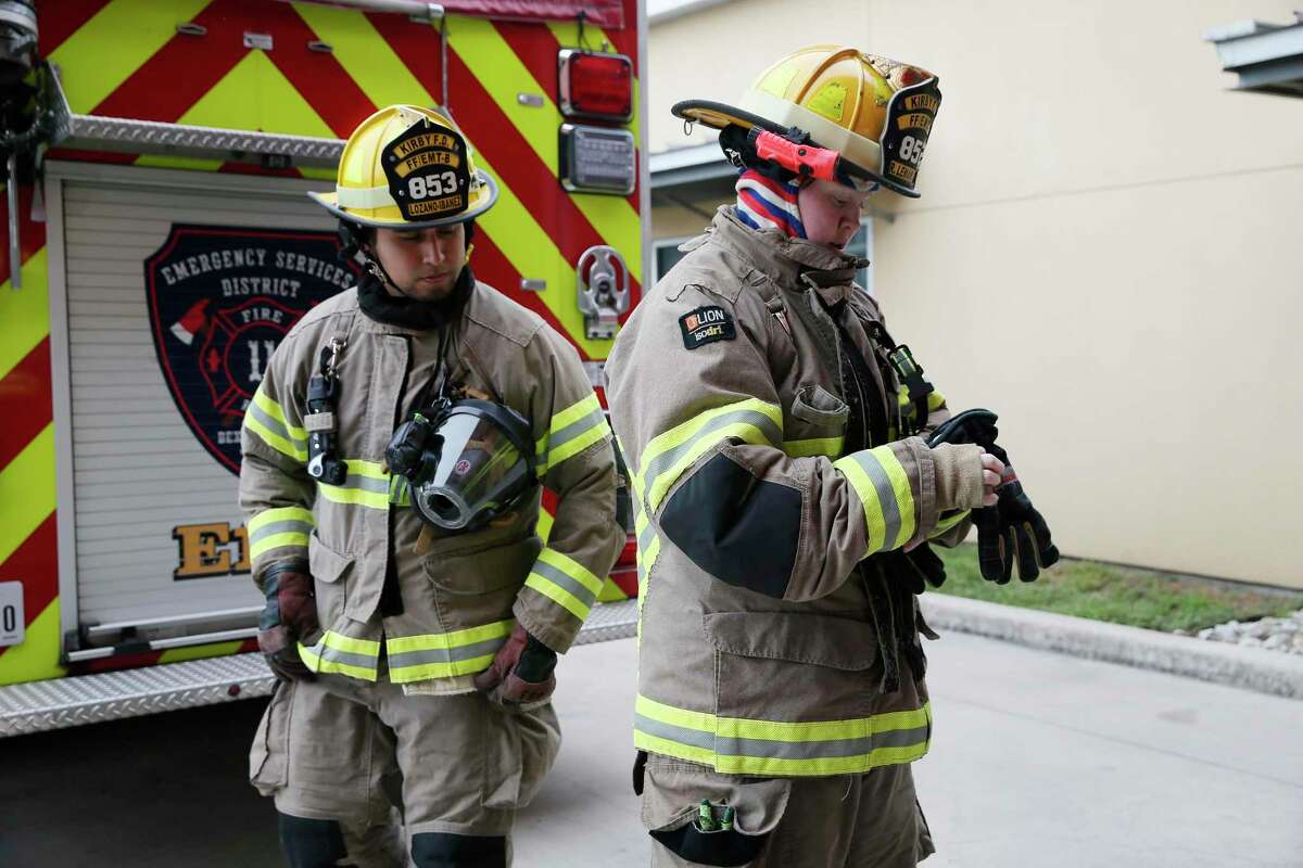 Kirby Fire Dept. Lt. Martin Lozano-Ibanez, 30, left, inspects engineer Becky Lemanski, 31, after a bunker drill on Sept. 15. Lemanski is in her third year with the department. The fire department is working on increasing gender diversity within its ranks, which are currently overwhelmingly male.
