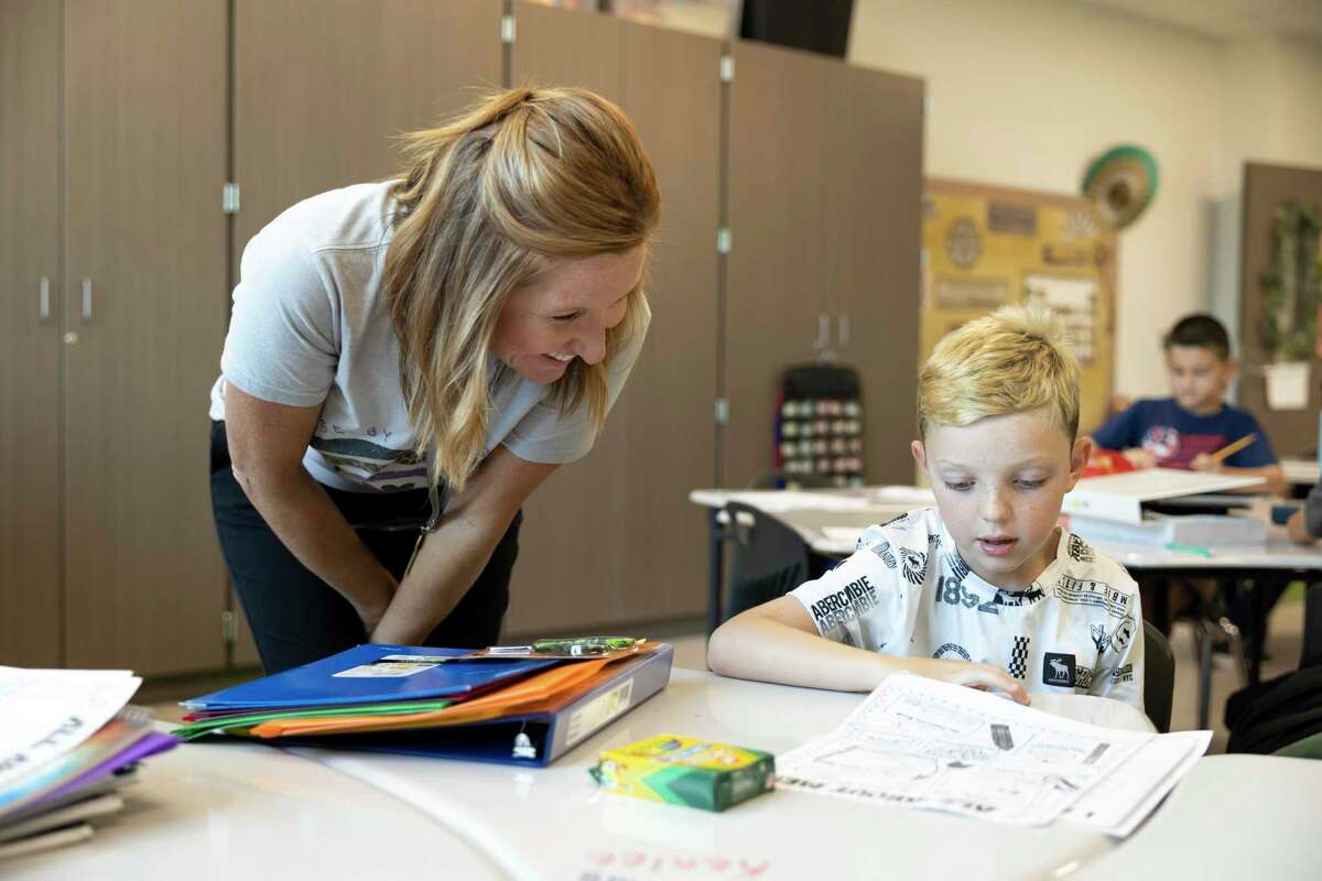Nichole Slott, third grade teacher, left, assists Lukas Grimm with an assignment during the first day of school at Eddie Ruth Lagway Elementary in August. Willis ISD is giving out retention bonuses to employees at the end of the month to extend an appreciation to teachers and other staff working for the district this school year.