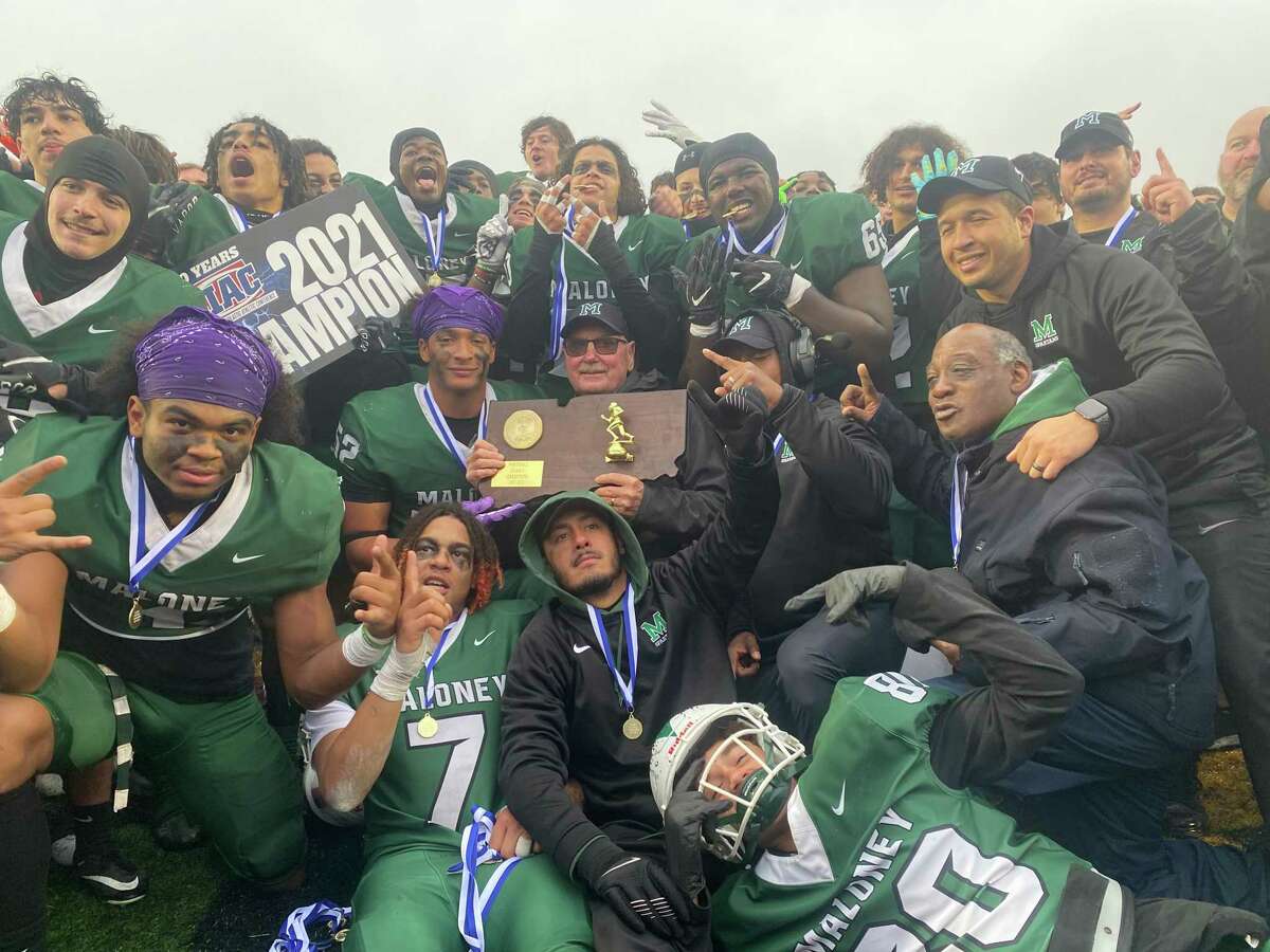 Members of the Maloney football program celebrate after defeating Windsor Saturday to win the school's first CIAC state football championship. Maloney defeated Windsor 35-21.