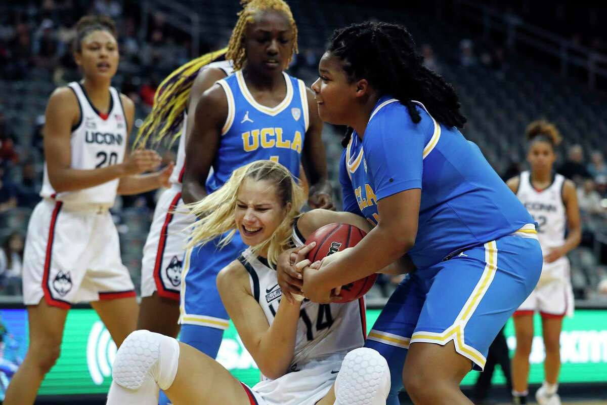 UConn’s Dorka Juhasz (14) and UCLA’s IImar'I Thomas battle for a rebound during the first half Saturday.
