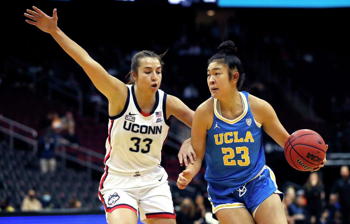 UCLA’s Natalie Chou (23) drives to the basket against UConn’s Caroline Ducharme during the first half Saturday.