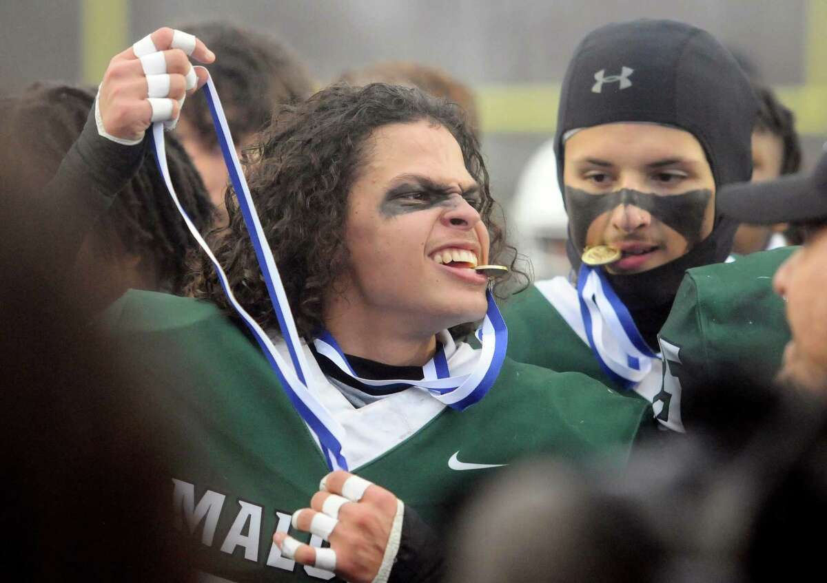 Maloney's Johnny Rosado celebrates with teammates after they defeated Windsor in CIAC Class L state championship football action at Veterans Stadium in New Britain, Conn., on Saturday December 11, 2021.