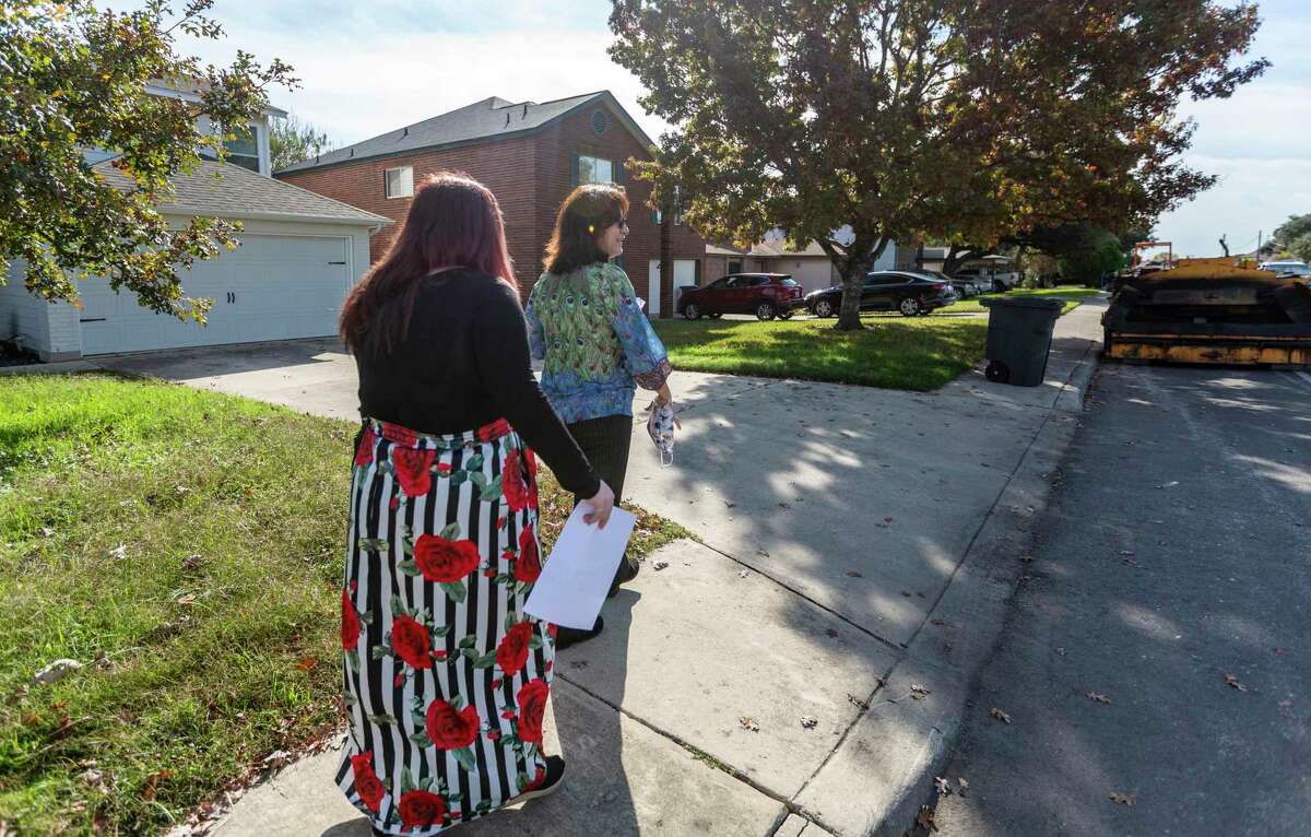 Christine Martinez, right, and Ashley Lee, walk to their car after talking with a parent whose child has a large number of school absences. The coronavirus pandemic has pushed some districts away from a punitive model of truancy enforcement to try instead to provide families with resources to make it easier for children to attend school.