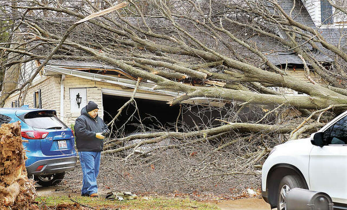 After striking an Amazon facility Friday night, the storm made a path of destruction heading northeast felling trees, destroying buildings and dropping hundreds of pieces of metal and insulation into the neighborhool off Country Club Drive. Here, Dave Chomhiran gets ready to start cutting up the tree that fell on his parents’ house in the first block of Glen Echo Drive. In the neighborhood trees fell everywhere, crushing the front end of a pickup truck. The storm continued to cut a path of destruction across several states.