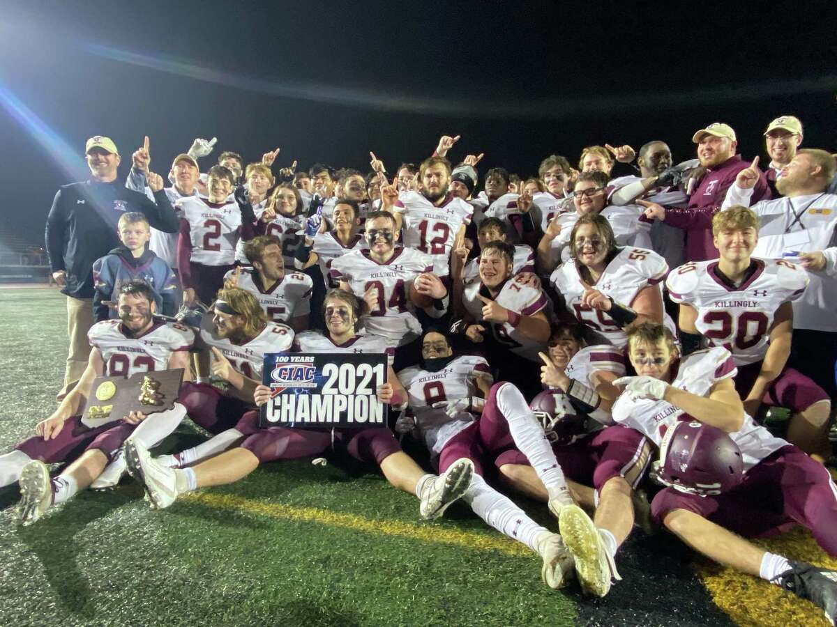 Members of the Killingly football team celebrate their Class M championship victory over Rockville Saturday.
