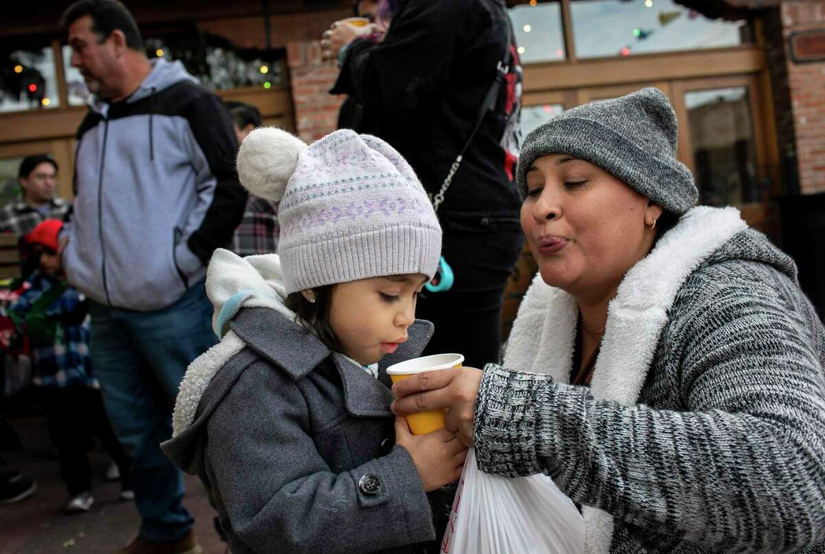 Isabel Esparza, 2, blows on her hot chocolate Saturday with her mother, Ana Esparza, during La Gran Tamalada, a culinary tradition hosted by La Familia Cortez Restaurants and Market Square. The event is being held Saturday and Sunday at Historic Market Square.