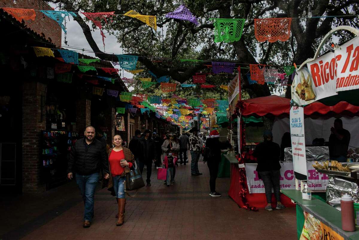 People walk past food vendors Saturday, Dec. 11, 2021, during La Gran Tamalada at Historic Market Square.