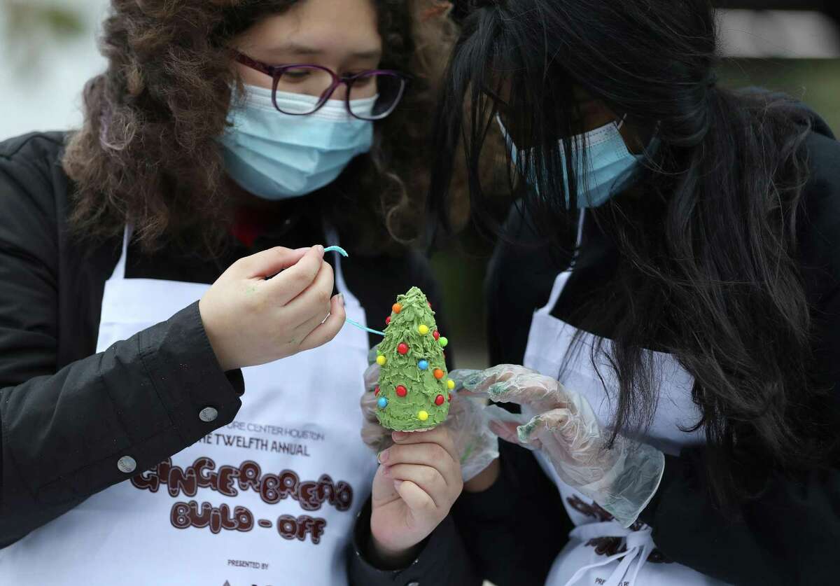 Izabella Vargas, left, and Aanya Jain, both 14, work on decorating a small Christmas tree for their display as Architecture Center Houston hosted the 12th annual gingerbread build-off at Levy Park, Saturday, Dec. 11, 2021 in Houston . Competing teams will create their masterpieces using 100 percent edible materials.